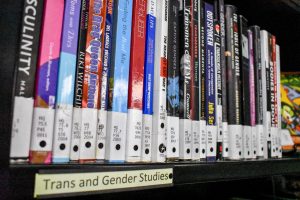A row of books in the LGBTCC include titles relating to Trans and Gender Studies