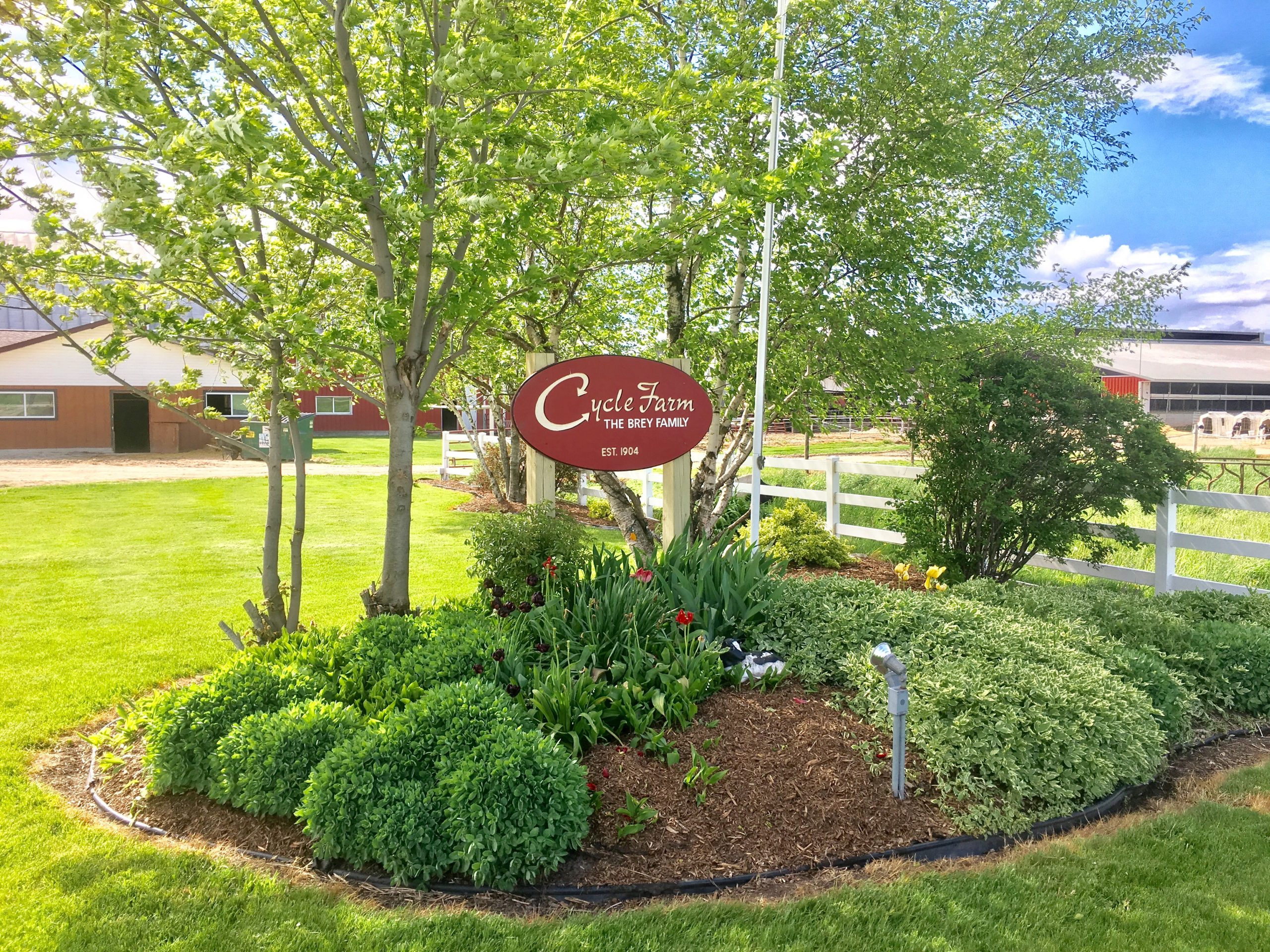 Image of the Brey Cycle Farm, with their family sign in the front yard.