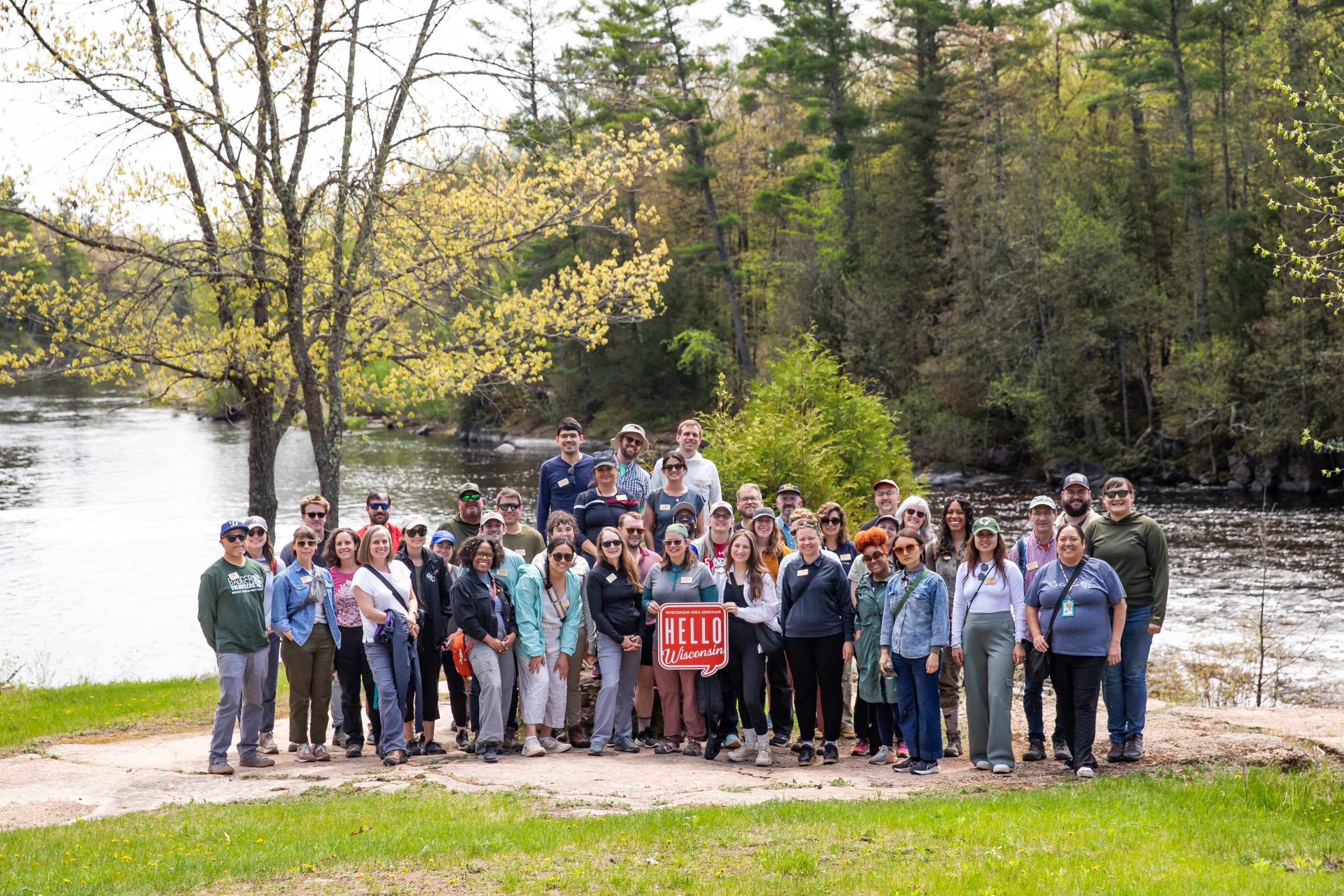 The 2025 Wisconsin Idea Seminar’s FOREST + RIVER cohort greet the water in the Menominee Reservation at Big Smokey Falls where the Wolf River drops 20 feet.